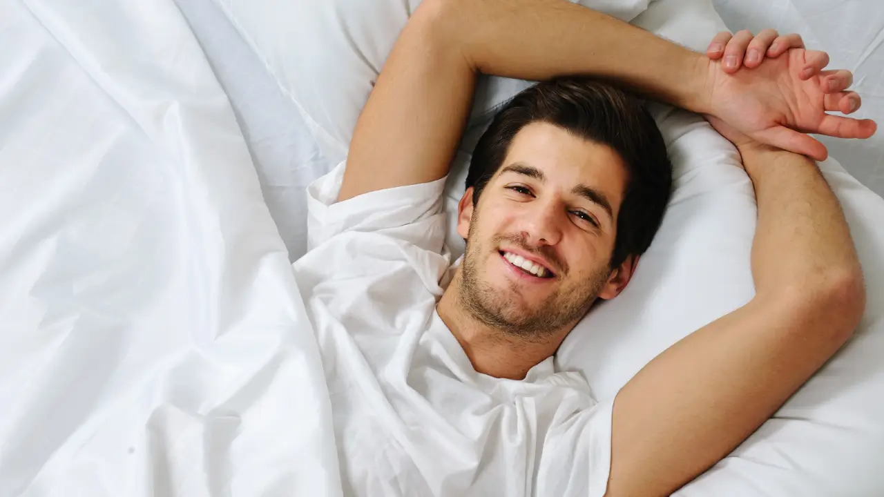 homem sorrindo deitado na cama